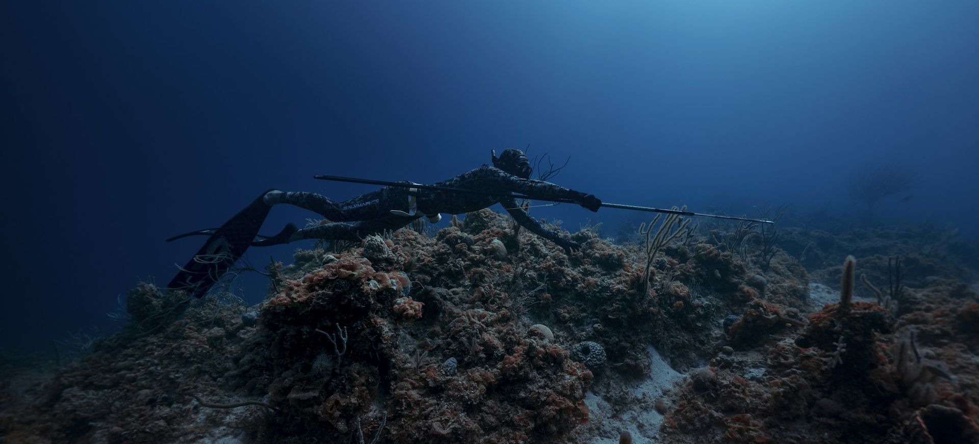 Chasseur sous-marin à l'agachon sur un sec, arbalète en main
